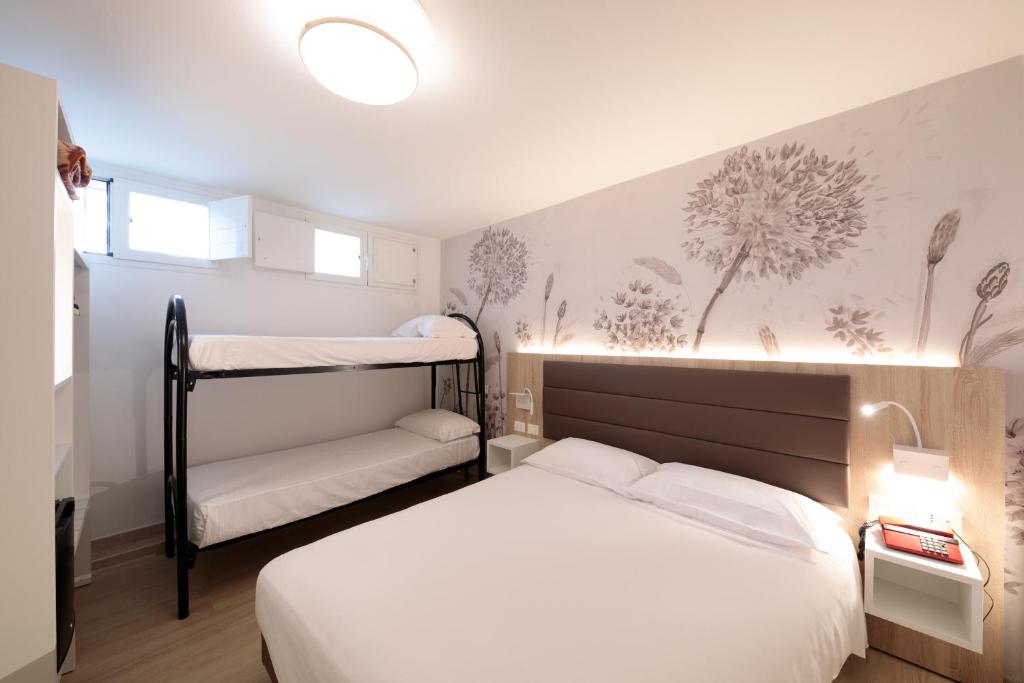 une chambre avec un lit et deux lits superposés dans l'établissement Hotel Derby S, à Lido di Jesolo 117 autres photos