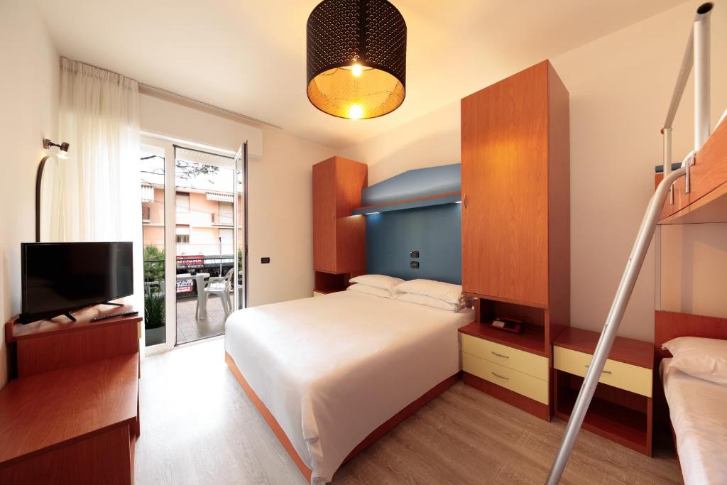 une chambre avec un grand lit et une télévision dans l'établissement Hotel Derby S, à Lido di Jesolo