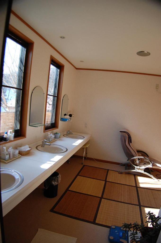 une salle de bain avec deux lavabos et deux miroirs dans l'établissement Sawatari Onsen Miyataya Ryokan, à Nakanojo