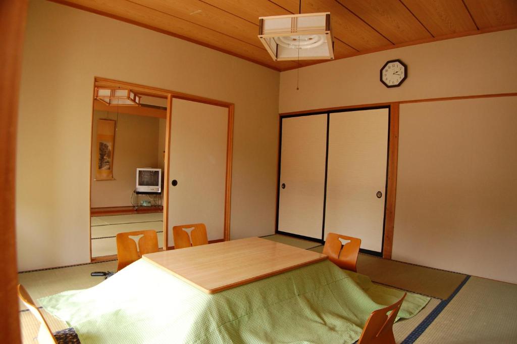 une chambre avec un lit et une horloge au mur dans l'établissement Sawatari Onsen Miyataya Ryokan, à Nakanojo