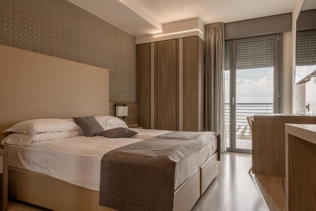 une chambre avec un lit et une grande fenêtre dans l'établissement Hotel Delle Nazioni - Adults Only, à Caorle