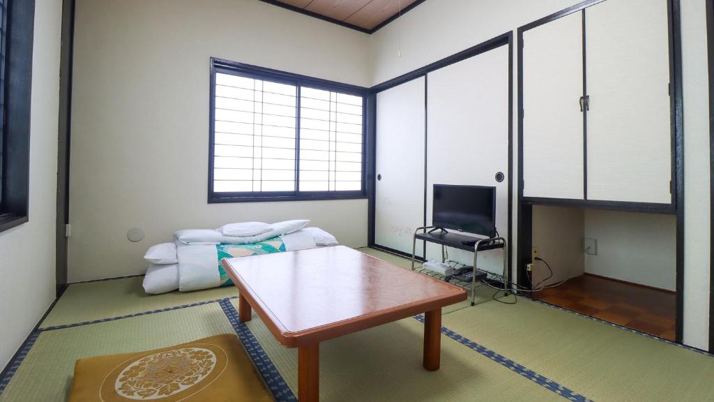 un salon avec une table et un lit dans l'établissement Iris Yu, à Hiraizumi
