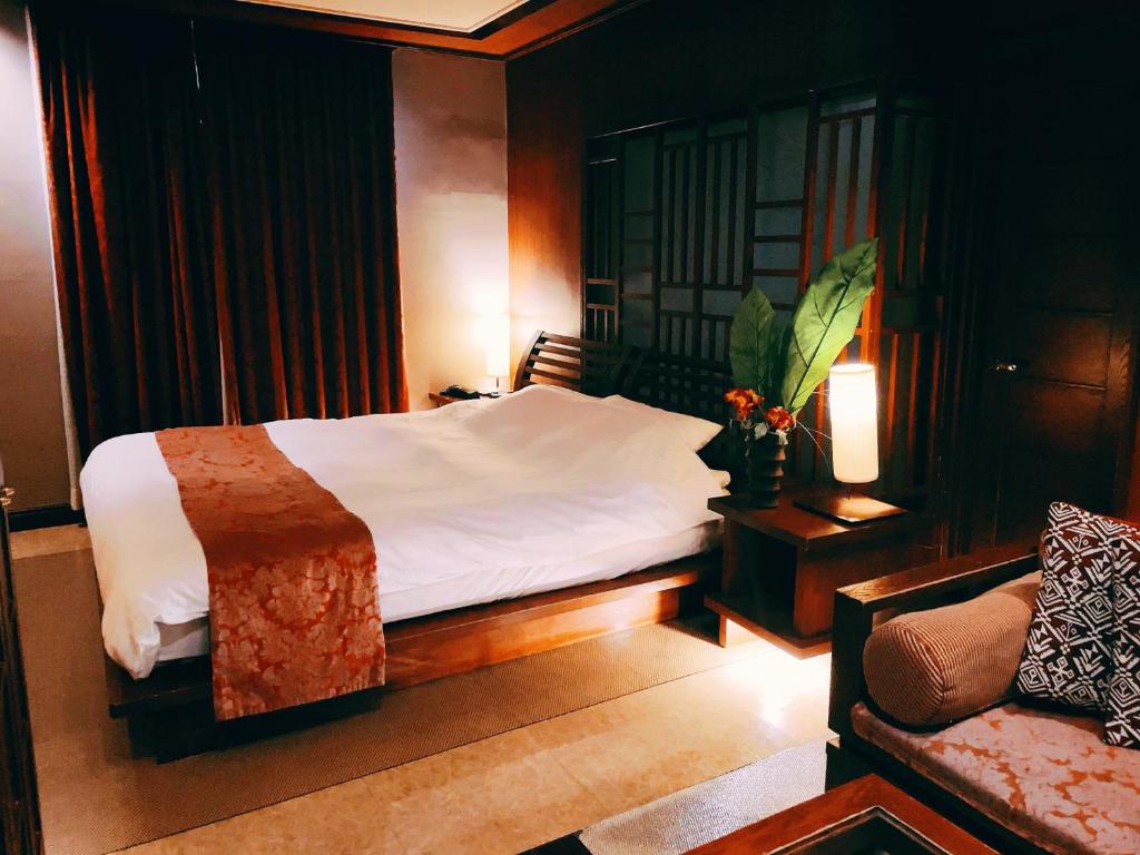 une chambre avec un lit et un canapé dans l'établissement HOTEL BALIS - Adult Only, à Shizukuishi