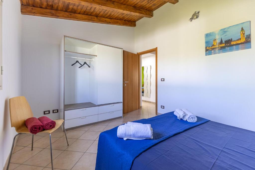 une chambre avec un lit bleu et une télévision dans l'établissement Villa Giacomo con piscina, à Santa Maria Del Focallo 19 autres photos