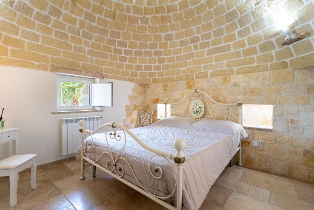 une chambre avec un lit dans un mur de briques dans l'établissement Trulli San Pietro, à Putignano 30 autres photos