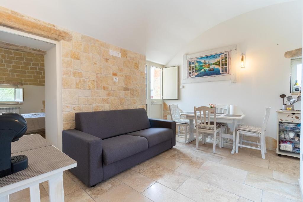 un salon avec un canapé et une table dans l'établissement Trulli San Pietro, à Putignano