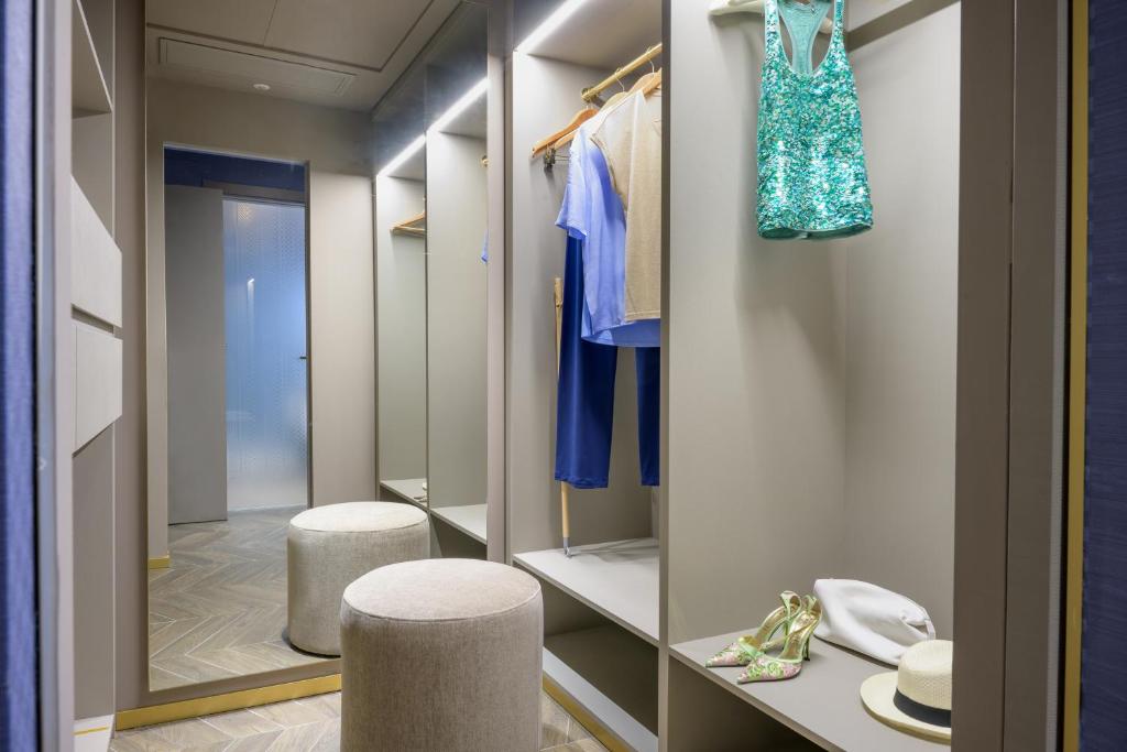 - un dressing avec deux tabourets et un porte-monnaie bleu dans l'établissement Hotel Il Negresco, à Forte dei Marmi