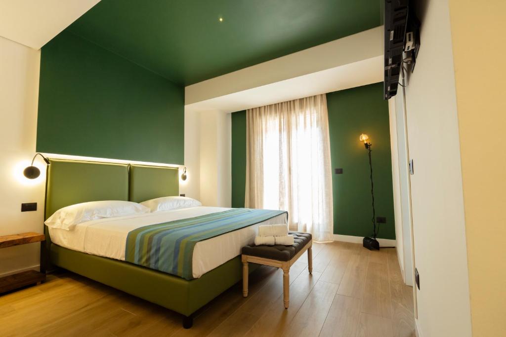 - une chambre verte avec un lit et un mur vert dans l'établissement Hotel Ristorante Le Rose, à Briatico