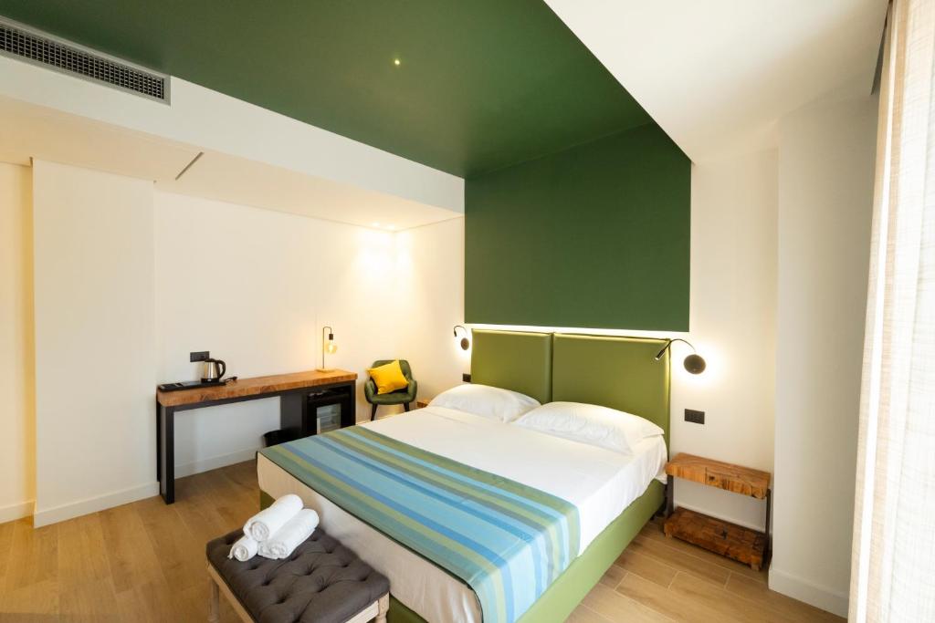 - une chambre dotée d'un lit avec un mur vert dans l'établissement Hotel Ristorante Le Rose, à Briatico