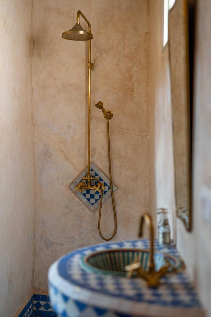 une salle de bain avec un lavabo et une douche dans l'établissement Riad Petite Rêverie, à Essaouira