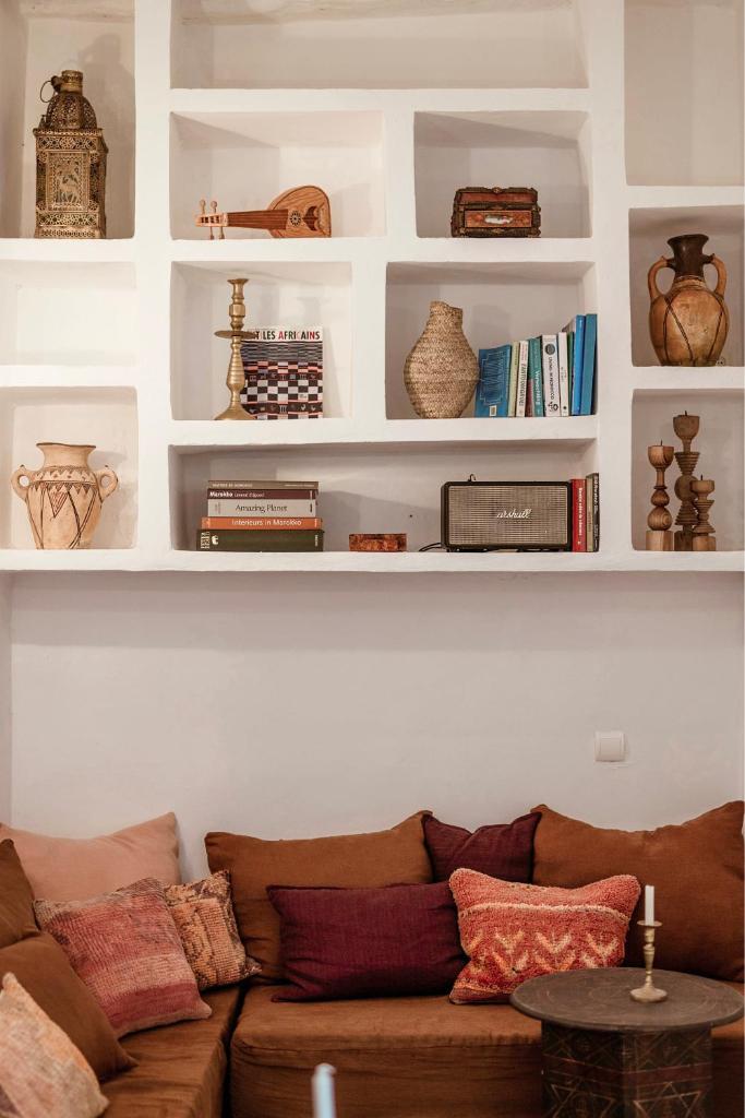 - un salon avec un canapé et des étagères avec des livres dans l'établissement Riad Petite Rêverie, à Essaouira