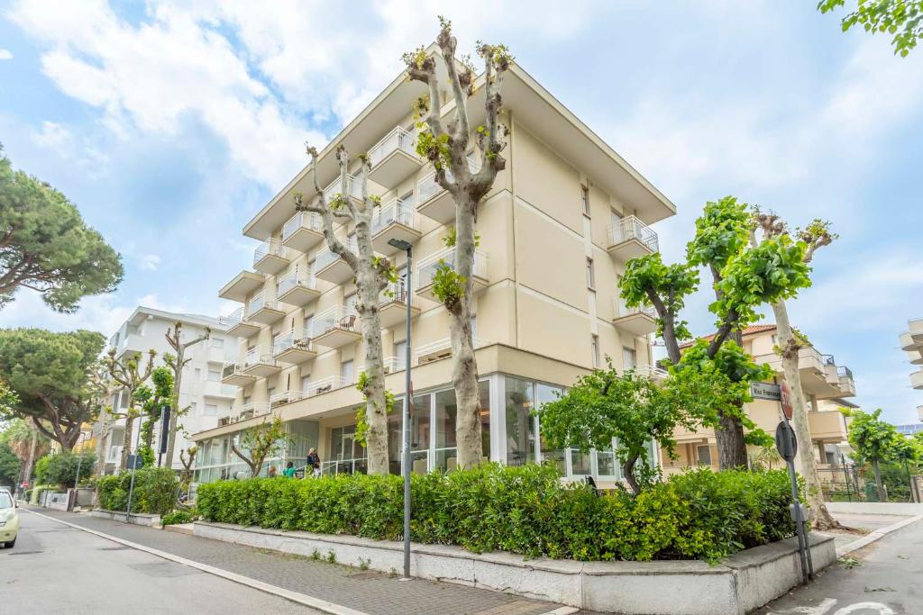 un bâtiment avec des arbres devant dans l'établissement Hotel Cormoran Riccione, à Riccione