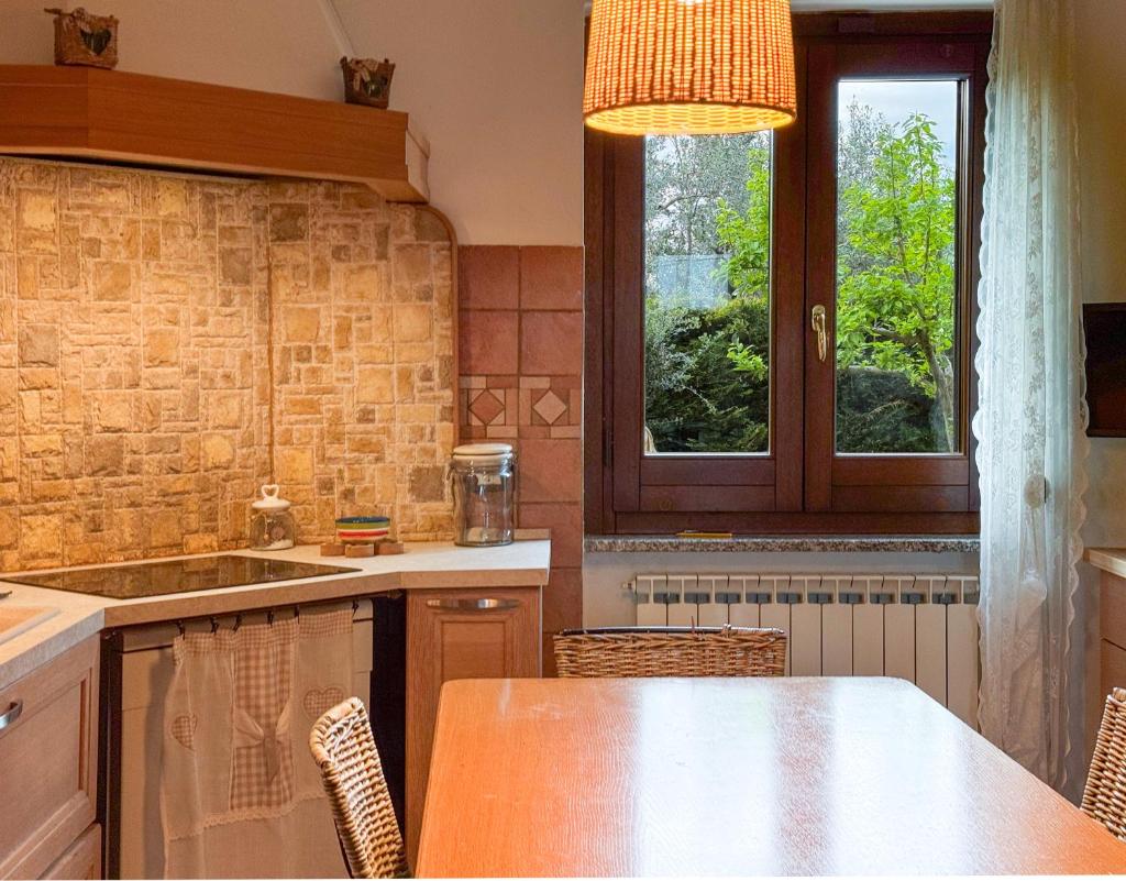 une cuisine avec une table et des chaises et une fenêtre dans l'établissement Casa dello Psiconauta - Atelier con giardino mediterraneo, à San Vito Chietino