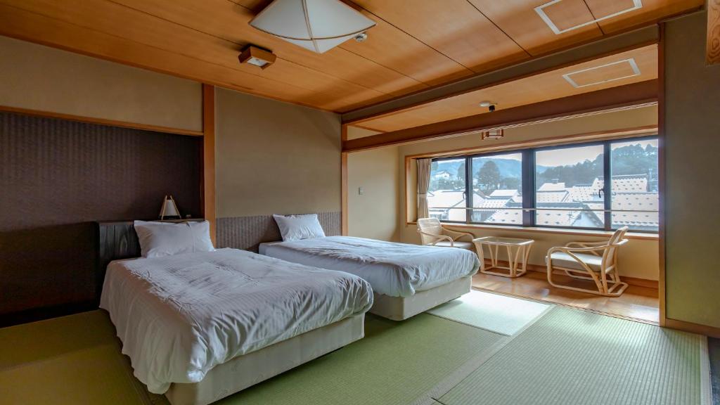 une chambre d'hôtel avec deux lits et un balcon dans l'établissement Sensui, à Toyooka 37 autres photos