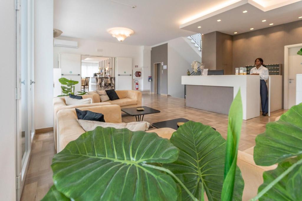 une femme debout à un comptoir dans un salon dans l'établissement Hotel Cormoran Riccione, à Riccione
