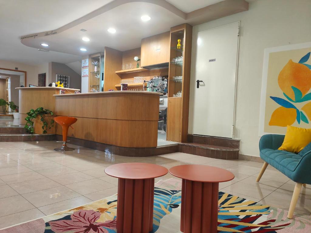 un hall d'entrée avec deux tabourets et une salle d'attente dans l'établissement Hotel Ben Hur, à Cesenatico