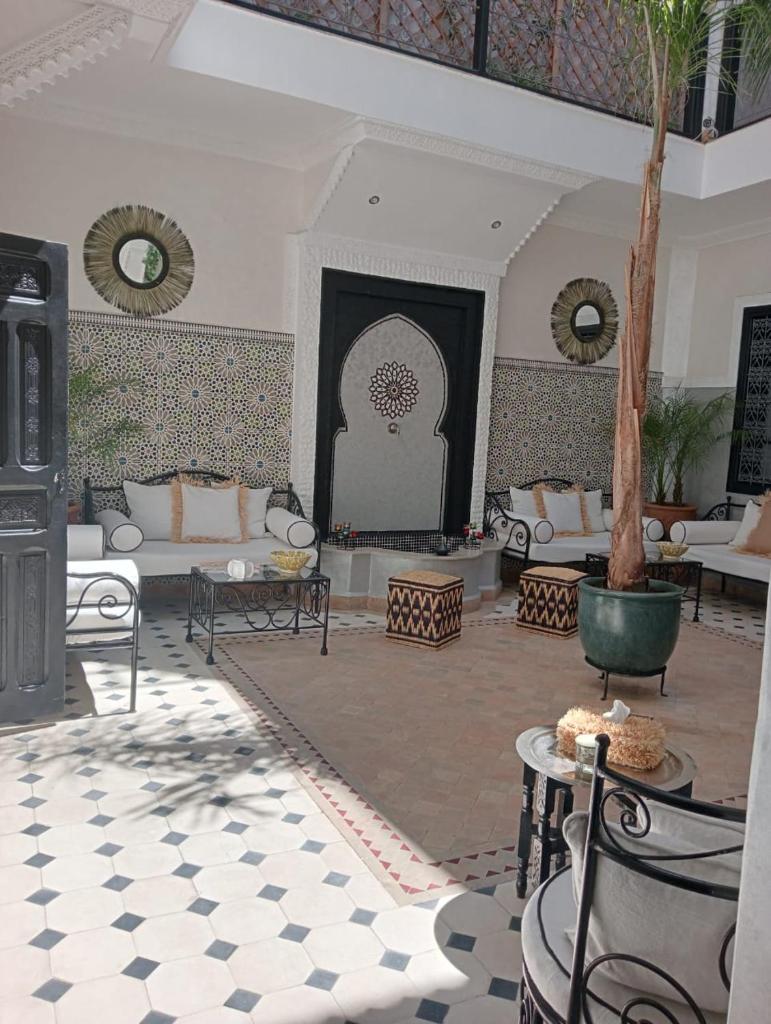 - un salon avec des canapés et un palmier dans l'établissement Le riad de l'étoile ocre - COTG, à Marrakech