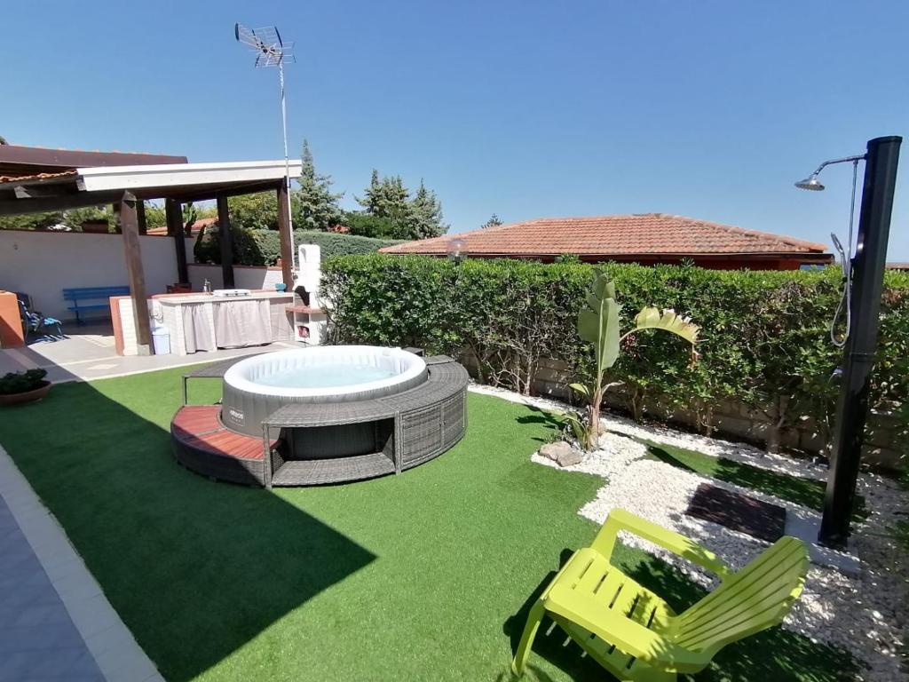 une cour avec un bain à remous et deux chaises longues dans l'établissement Villa Mykonos, à Fontane Bianche