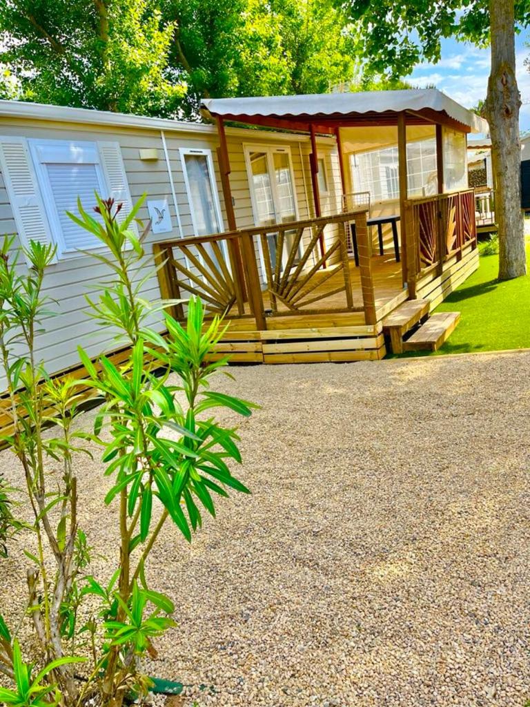 une grande cabane en bois avec un porche sur une maison dans l'établissement Mobil Home 2CH Bien Equipé Valras-Plage, à Sérignan