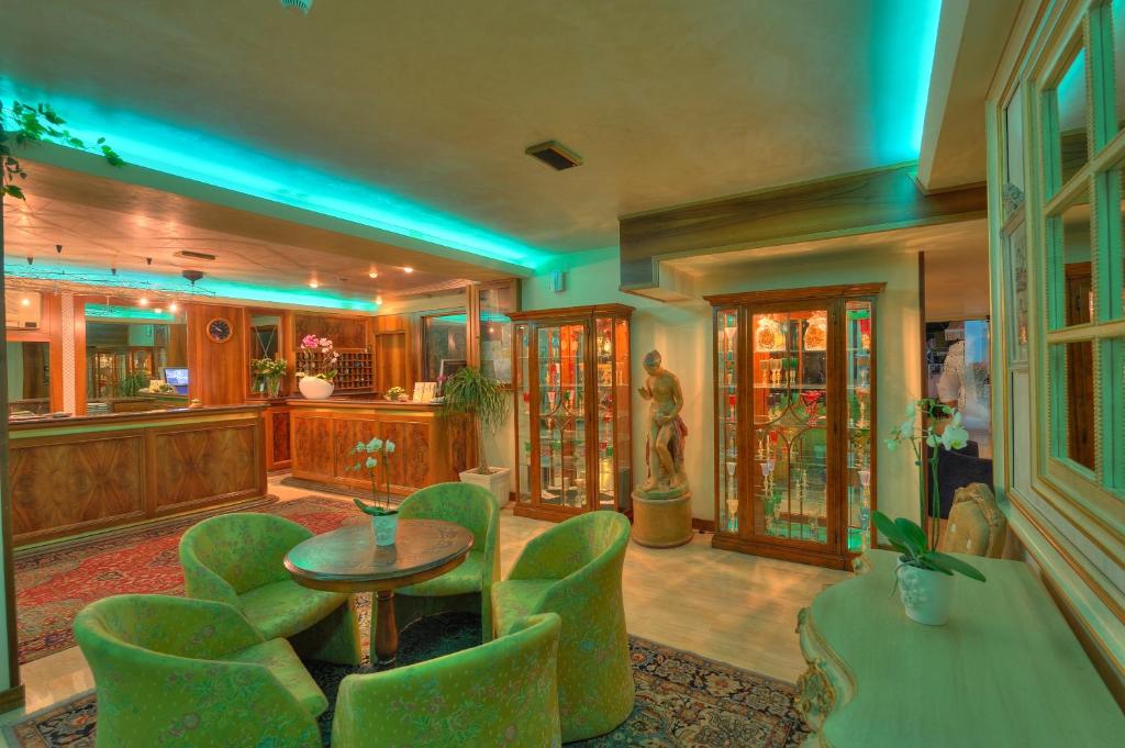 - un salon avec une table et des chaises vertes dans l'établissement Hotel Miramare, à Lignano Sabbiadoro 165 autres photos