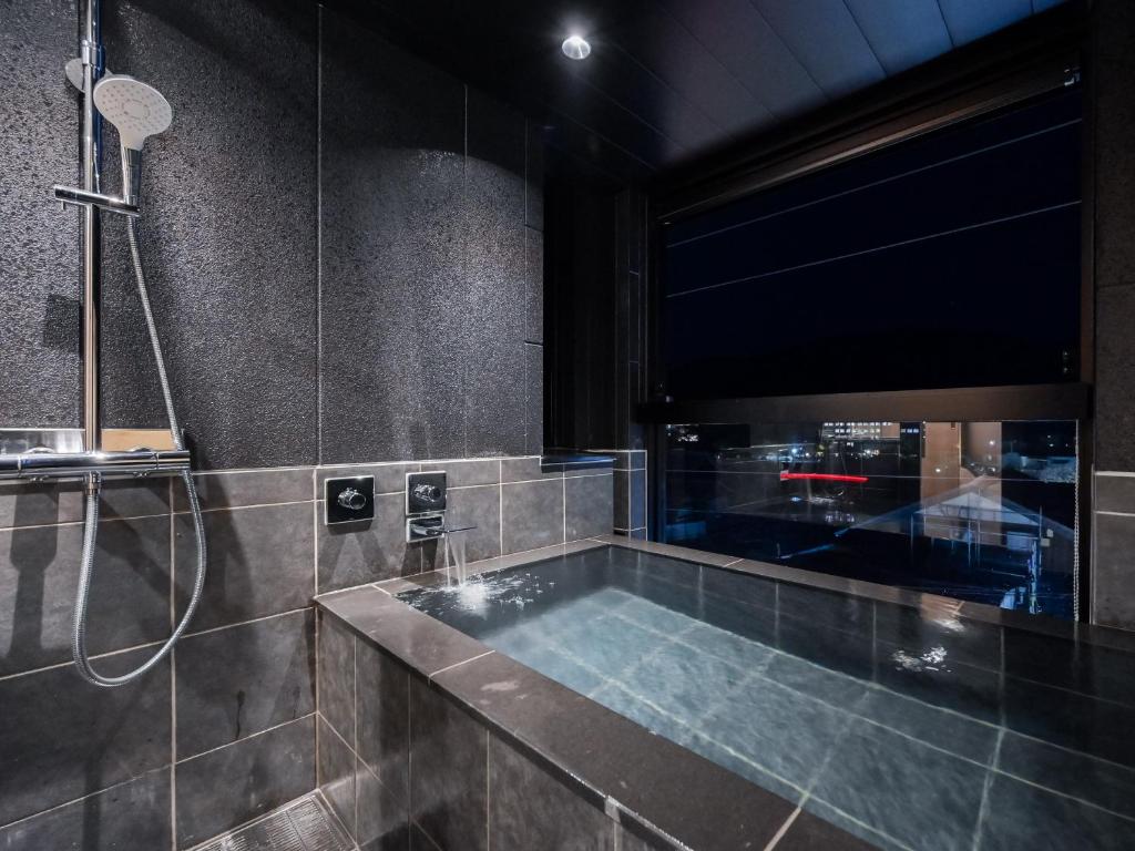 La salle de bains est pourvue d'une grande baignoire et d'une douche. dans l'établissement Ureshino Onsen Yadoya Uchiroji, à Ureshino 32 autres photos