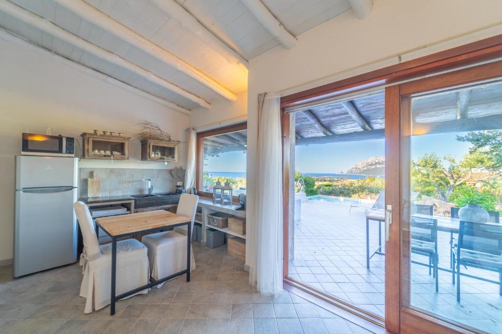 une cuisine avec une table et une vue sur l'océan dans l'établissement Sa Muda by DomusAway, à Porto San Paolo