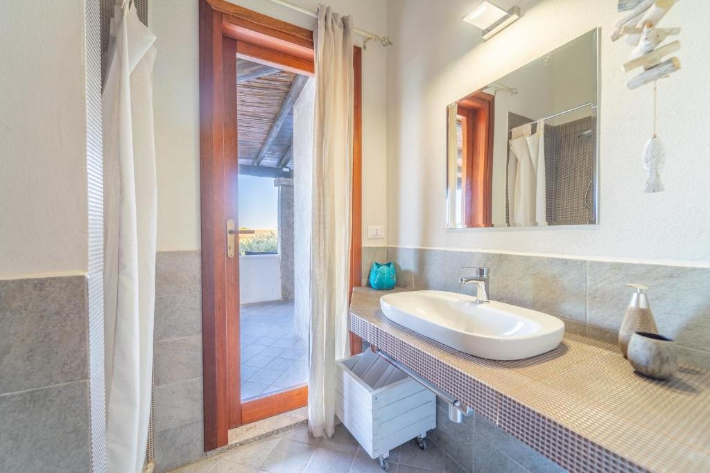 une salle de bain avec un lavabo et un miroir dans l'établissement Sa Muda by DomusAway, à Porto San Paolo