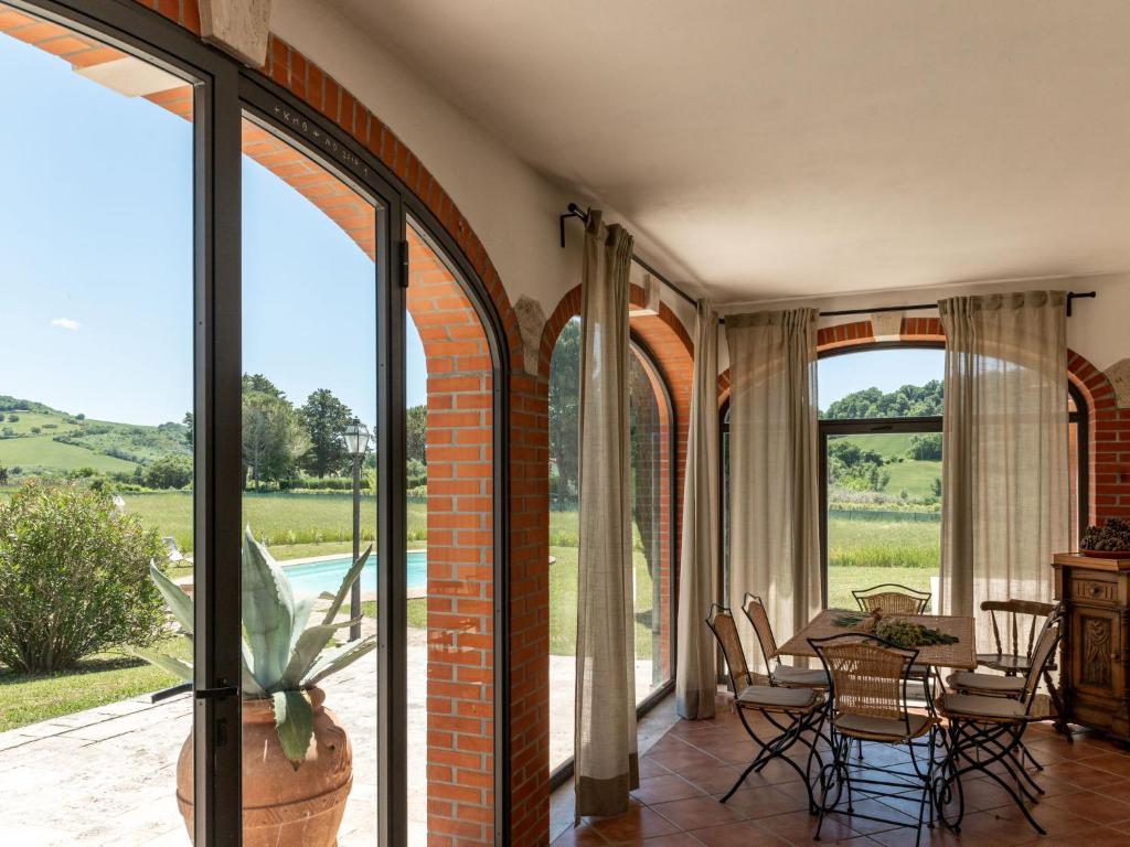 une salle à manger avec des portes en verre et une table dans l'établissement Villa Le Cascate by Interhome, à Saturnia