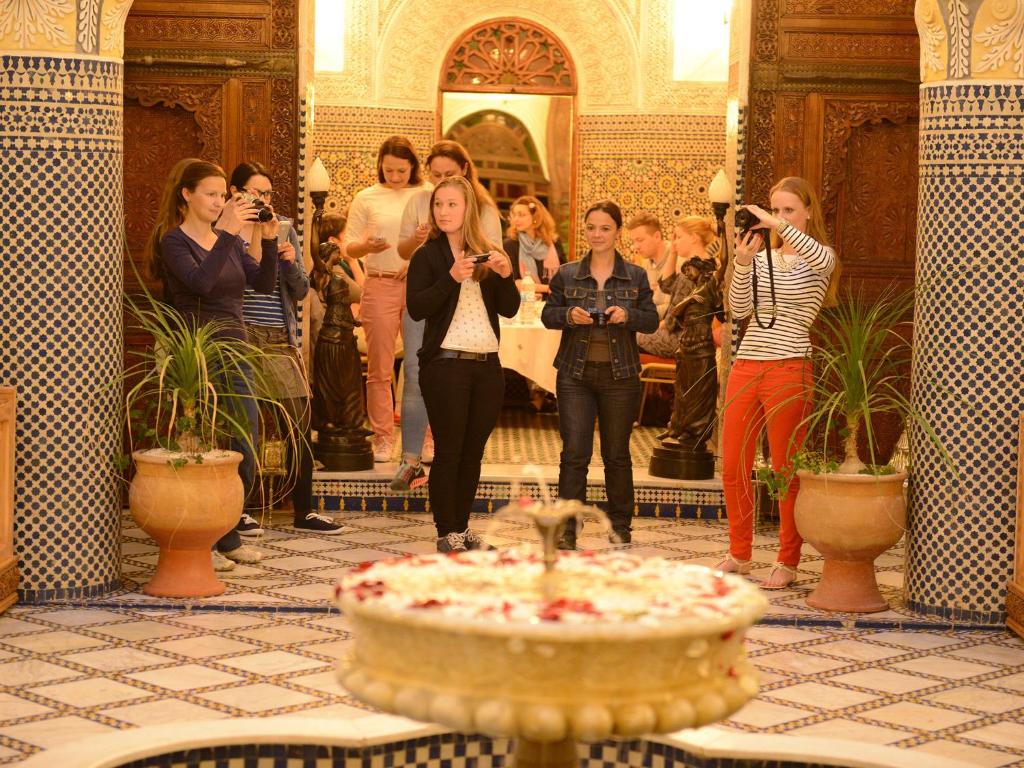 un groupe de personnes prenant des photos d'une fontaine dans un bâtiment dans l'établissement Riad El Yacout, à Fès 37 autres photos