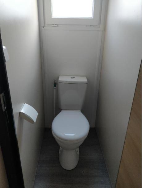 Elle comprend une petite salle de bains pourvue de toilettes et d'une fenêtre. dans l'établissement Village vacances l'endorph'in, à Déols