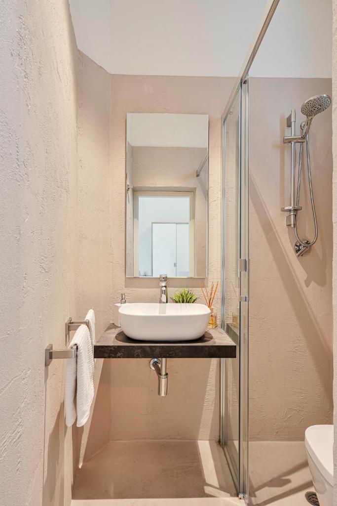 une salle de bain avec un lavabo et un miroir dans l'établissement Hotel Lux, à Gabicce Mare 67 autres photos