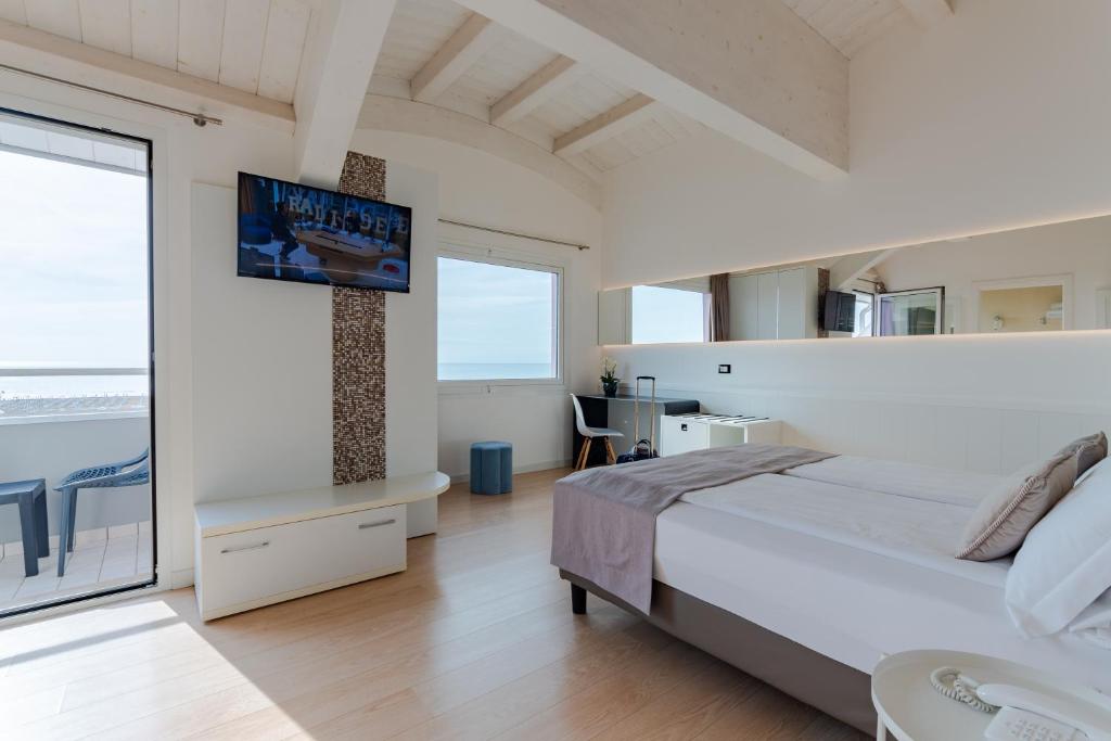une chambre avec un lit et une télévision sur un mur dans l'établissement Hotel Lux, à Caorle