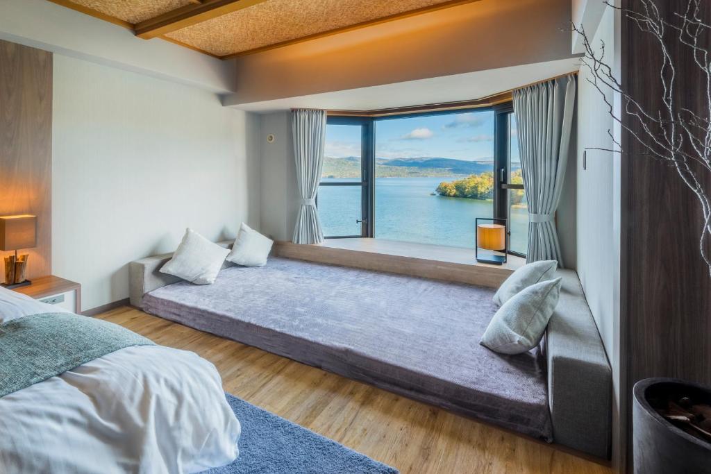 une chambre avec un lit et une grande fenêtre dans l'établissement New Akan Hotel, à Akankohan
