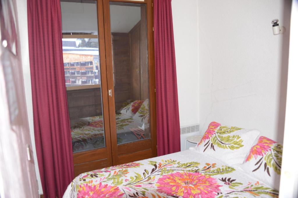 - une chambre avec une armoire en verre à côté d'un lit dans l'établissement Les Pralyssimes - 35 M², à Taninges