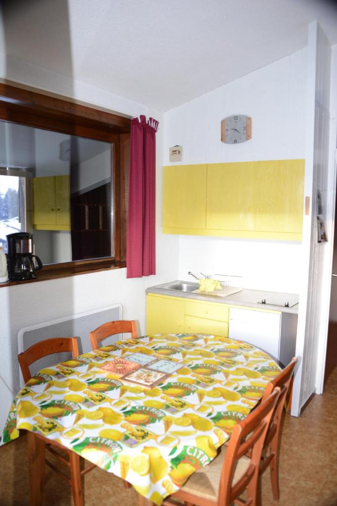 - une cuisine avec une table et une couverture colorée dans l'établissement Les Pralyssimes - 35 M², à Taninges