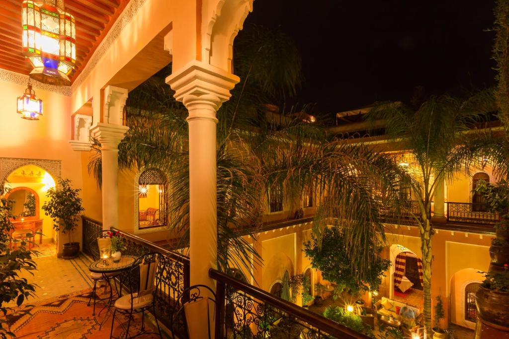 un bâtiment avec un balcon avec des plantes dessus dans l'établissement Riad Amina, à Marrakech