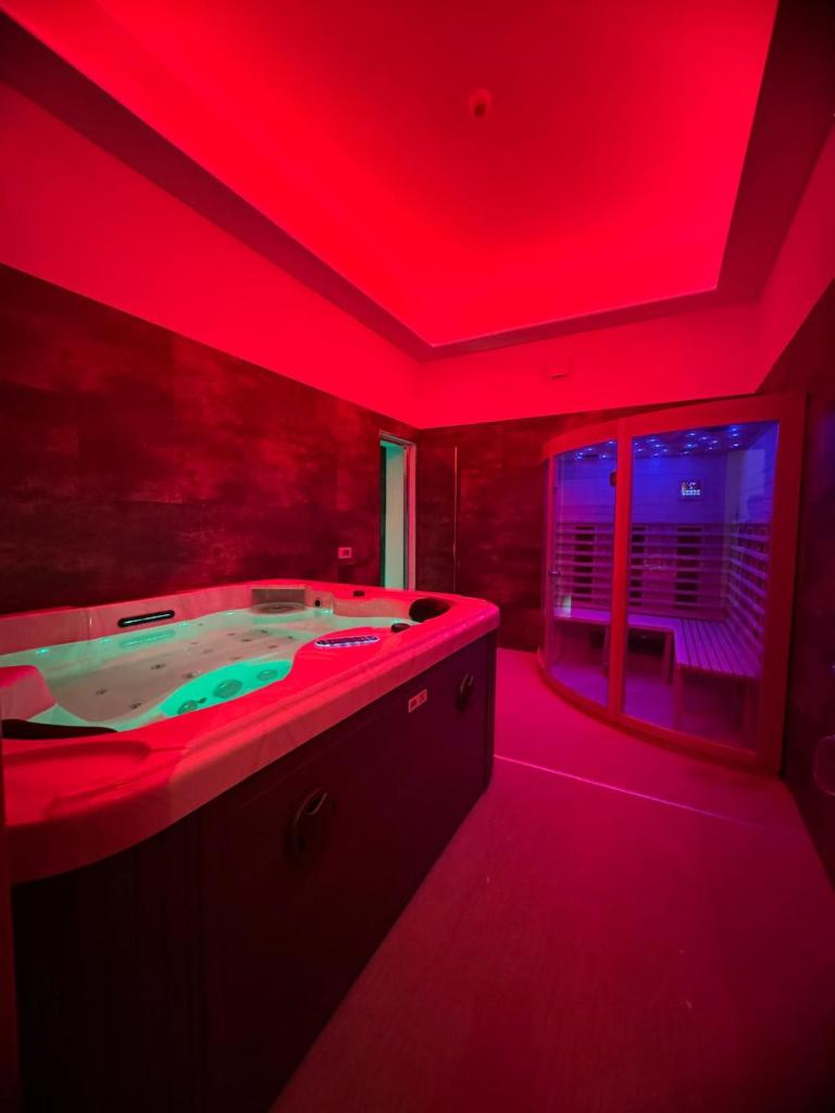 une salle de bain avec un bain à remous avec un éclairage rouge dans l'établissement Hotel Butterfly Wellness & Spa, à Rimini
