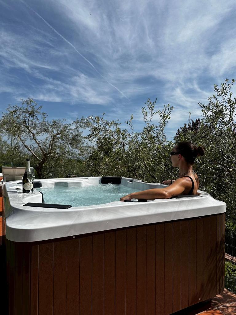 une femme est assise dans un bain à remous dans l'établissement Il Villino del Daino - Toscana, à Loro Ciuffenna