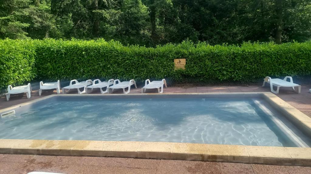 une grande piscine avec des chaises dans l'établissement location mobil-home le parc des roches, à Saint-Chéron