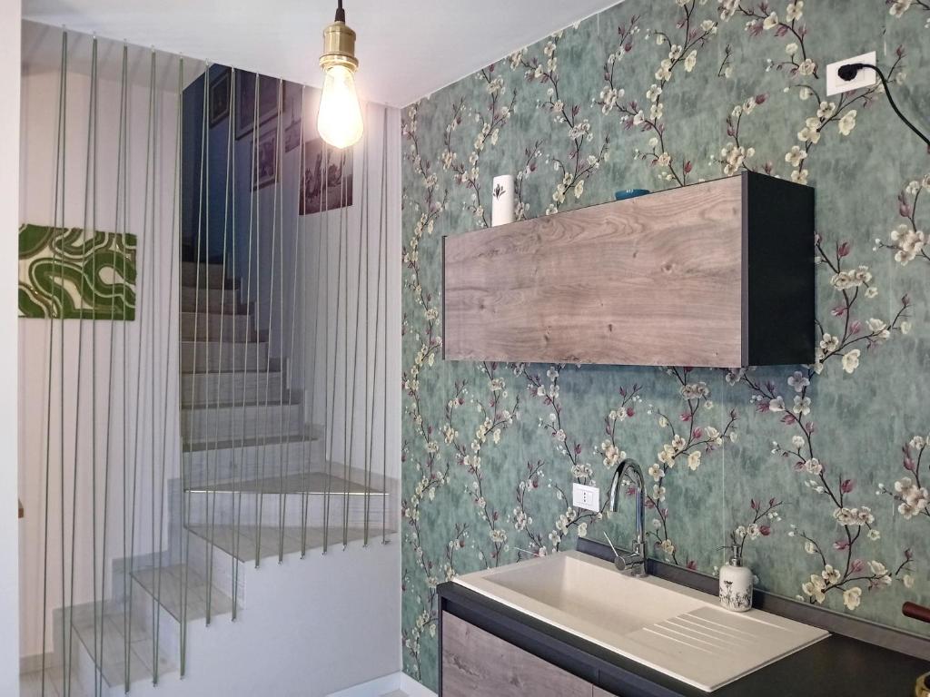 La salle de bains est pourvue d'un lavabo et d'un escalier. dans l'établissement B&B Tra colline marchigiane - sauna e piscina, à San Giorgio di Pesaro