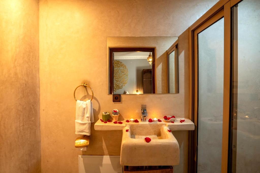 une salle de bain avec un lavabo et un miroir dans l'établissement Riad Flamme D'Orient & Spa, à Marrakech