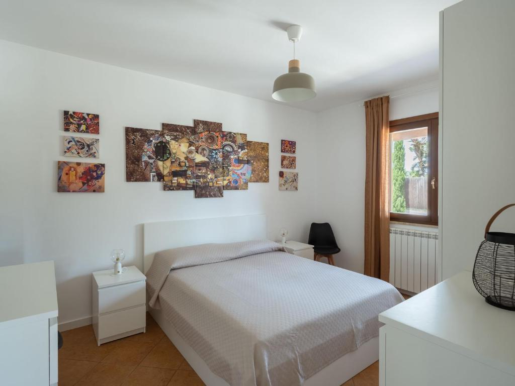 - une chambre avec un lit et des photos sur le mur dans l'établissement Villa Kamarà, à Castellammare del Golfo