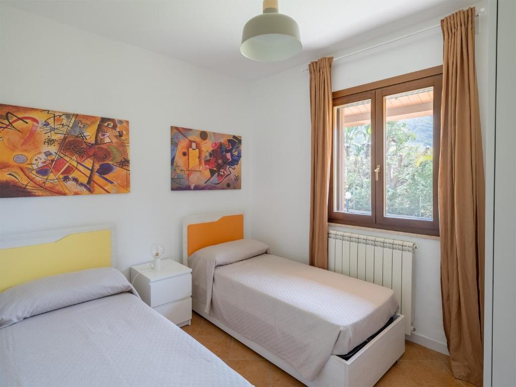 une chambre avec deux lits et une fenêtre dans l'établissement Villa Kamarà, à Castellammare del Golfo
