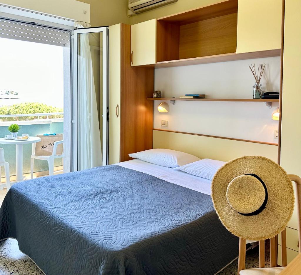 une chambre avec un lit bleu et un balcon dans l'établissement Hotel Pacific, à Riccione