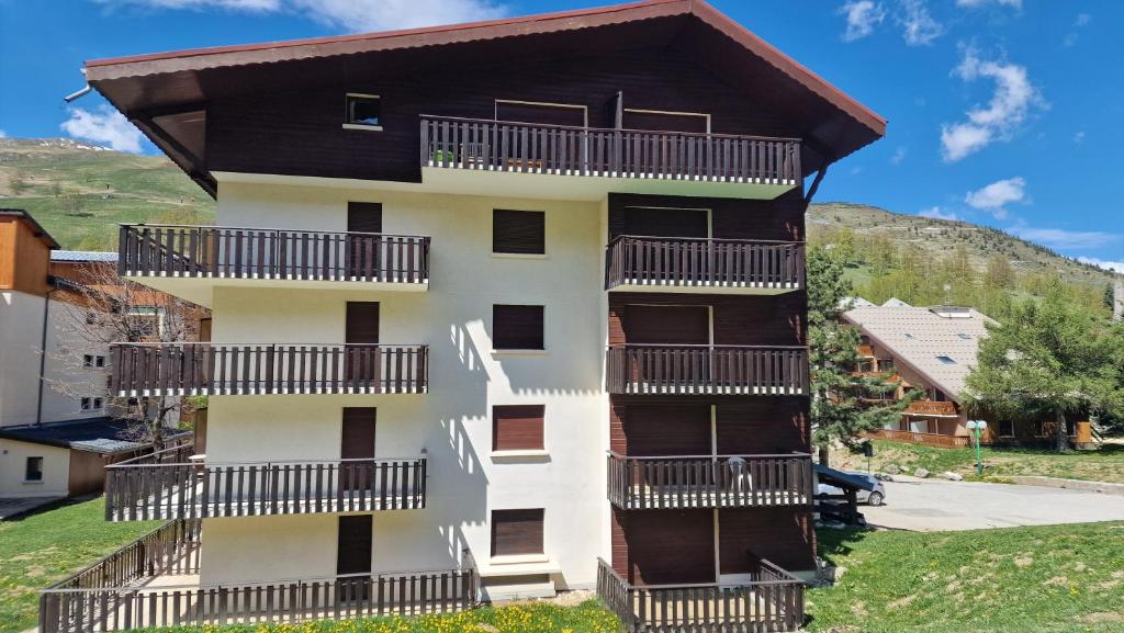 un bâtiment avec des balcons sur le côté dans l'établissement Les Brimbelles 27 studio au pied du télémix de Belle Étoile, à Les Deux Alpes