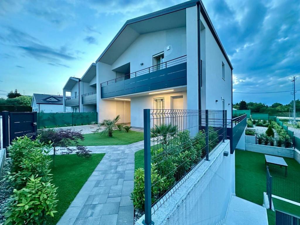 Cette maison blanche dispose d'un balcon et d'une cour. dans l'établissement Villa al Borghetto, à Cavalcaselle