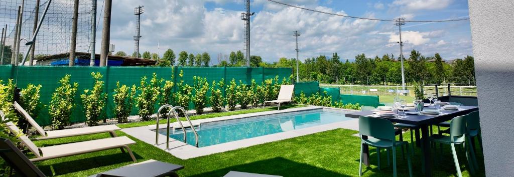 une piscine dans une cour avec une table et des chaises dans l'établissement Villa al Borghetto, à Cavalcaselle