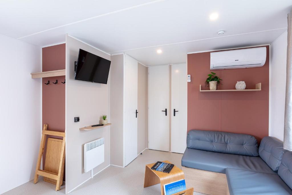 un salon avec un canapé et une télévision dans l'établissement Camping 4 étoiles Piscines et Plage 3 chambres 6 pers - Mallet, à La Turballe