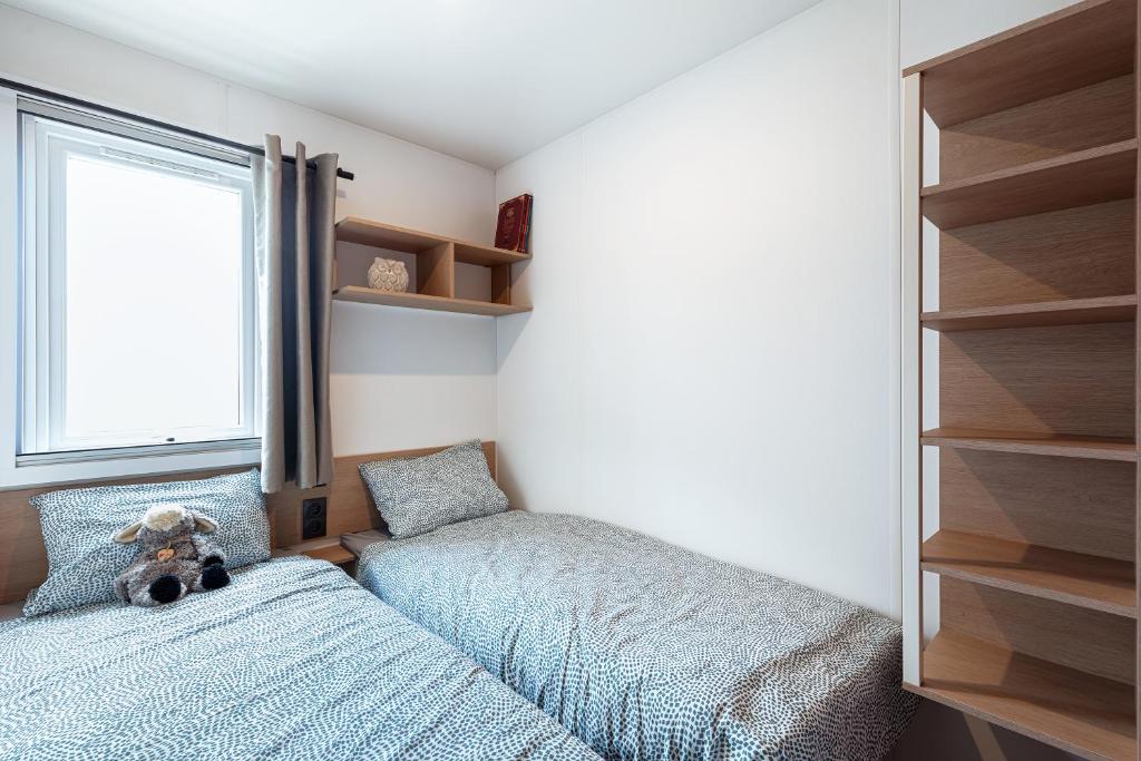 une chambre avec deux lits jumeaux et une fenêtre dans l'établissement Camping 4 étoiles Piscines et Plage 3 chambres 6 pers - Mallet, à La Turballe
