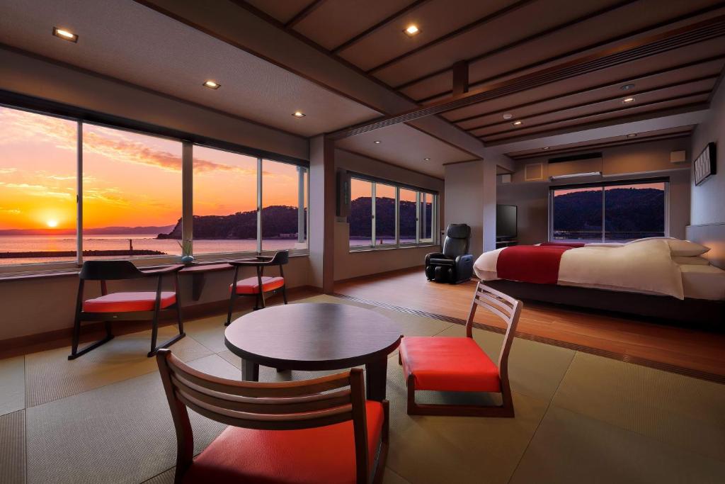 une chambre avec un lit, une table et des chaises dans l'établissement Uminoniwa, à Kamogawa